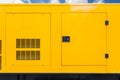 Big yellow mobile diesel box of autonomous generator for emergency electric power stand outside with blue cloud sky