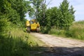 Big yellow tractor in the forest. Construction equipment in the forest