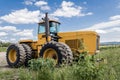 Big yellow tractor on sunflower and corn field blue cloudy sky Royalty Free Stock Photo