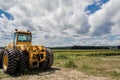 Big yellow tractor on sunflower and corn field blue cloudy sky Royalty Free Stock Photo