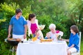 Big young family grilling meat for lunch with grandmother Royalty Free Stock Photo