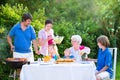 Big young family grilling meat for lunch on sunny day Royalty Free Stock Photo