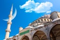 The biggest iconic mosque The Blue Mosque in Istanbul, Turkey with blue cloudy sky and crescent moon. Islam, moslem and Ramadan