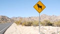 Bighorn sheep or ram crossing yellow road sign, California USA. Wild animal xing Royalty Free Stock Photo