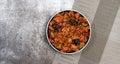Bigos - traditional polish dish of stewed sauerkraut with prunes and sausages on a round plate on a dark gray background Royalty Free Stock Photo
