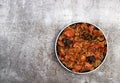 Bigos - traditional polish dish of stewed sauerkraut with prunes and sausages on a round plate on a dark gray background Royalty Free Stock Photo