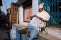 BIHAR, INDIA: Elderly asian man reads a newspaper outdoor at the evening