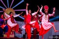 Sikh artists performing Bhangra dance on stage