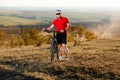 Bike adventure travel photo. Bike tourist rides on the country road. Sunset on background. Royalty Free Stock Photo