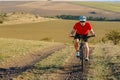 Bike adventure travel photo. Bike tourist rides on the country road. Sunset on background. Royalty Free Stock Photo