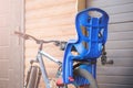 Bike with children carrying seat attached. Cycle with kids transportation equipment stand near wooden garage. Famil