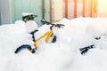 Bike covered with big thick snow layer after blizzard at european city street in winter. Abandoned bicycle buried in snowstorm