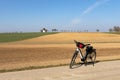 Bike at the edge of a field road near a plowed and sown field