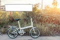 Bike folding parked on meadow with white poster