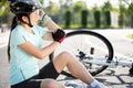 Bike injuries. Young woman cyclist fell fell off road bike while cycling. Bicycle accident, injured knee Royalty Free Stock Photo