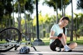 Bike injuries. Young woman cyclist fell fell off road bike while cycling. Bicycle accident, injured knee Royalty Free Stock Photo