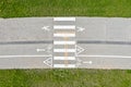 Bike lane among green lawn. white road marking with signs, arrows and zebra on the pavement. aerial view Royalty Free Stock Photo