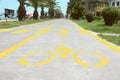 Bike lane with painted yellow bicycle sign and arrow near pedestrian crossing, closeup Royalty Free Stock Photo