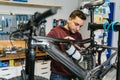 Bike mechanic manipulates the suspension system of an electric mountain bike using a ratchet wrench.