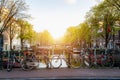 Bike over canal Amsterdam city in Netherlands with view on river Amstel during sunset Royalty Free Stock Photo