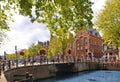 Bike over canal Amsterdam city. Picturesque town landscape with small bridge and old buildings facade in Netherlands w Royalty Free Stock Photo