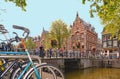 Bike over canal Amsterdam city. Picturesque town landscape with small bridge and old buildings facade in Netherlands w Royalty Free Stock Photo