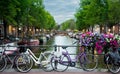 Bike over canal in Amsterdam city at sunset. Water taxi in background of Picturesque town landscape in Netherlands with view on Royalty Free Stock Photo