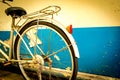 The bike parked next to the old white and blue peeling paint concrete wall Royalty Free Stock Photo