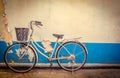 The bike parked next to the old white and blue peeling paint concrete wall Royalty Free Stock Photo