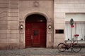 A bike parked outside a red old door with lights Royalty Free Stock Photo