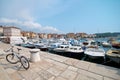 The bike is parked on the pier in port of Rovinj, Croatia. Yachts landing, motorboats and boats on water, medieval vintage houses Royalty Free Stock Photo