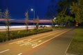 Bike path and alley in the park on the embankment in the late evening. White lines on the sidewalk Royalty Free Stock Photo