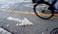 Bike path in city with bicycle wheel in motion Royalty Free Stock Photo