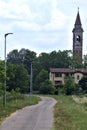 Bike path in the italian countryside in summer with a bell tower in the distance Royalty Free Stock Photo