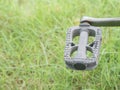 Bike pedal in green background.