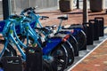 A bike rack with blue bikes on a red brick sidewalk in downtown Atlanta