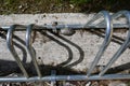 Bike rack with hidden kindness rock below and shadows on sunny day Royalty Free Stock Photo