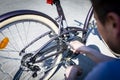 Bike repair. The man tightens the screw at the brakes with the key Royalty Free Stock Photo