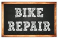 BIKE REPAIR words on black wooden frame school blackboard