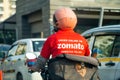 bike rider delivery boy with hot box branded with zomato the food tech delivery app in India and the iconic red uniform