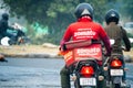 bike rider delivery boy with hot box branded with zomato the food tech delivery app in India and the iconic red uniform