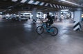 rider rides on an underground parking lot. A cyclist rides in an underground parking lot Royalty Free Stock Photo