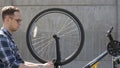 Bike service: mechanic layman repairman tuning bicycle brake on wheel outdoors