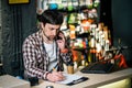 Bike shop owner at work. Store employee takes an order by mobile phone at table near laptop in travel and sporting goods store. Royalty Free Stock Photo