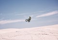 Bike, sky and jump with a man in the desert riding a vehicle for adventure or adrenaline. Motorcycle, speed and training