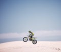 Bike, sky and jump with a man on mockup riding a vehicle in the desert for adventure or adrenaline. Motorcycle, speed