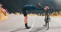 Bike, street cycling and stretching with a sports man at the start of fitness, exercise or training on an asphalt road Royalty Free Stock Photo