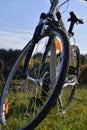 Bike wheel on a green grass autumn landscape blue sky background Royalty Free Stock Photo