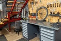 Bike workshop with metal workbench holding bicycle wheel tools hanging Royalty Free Stock Photo