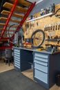 Bike workshop with metal workbench holding bicycle wheel tools hanging Royalty Free Stock Photo
